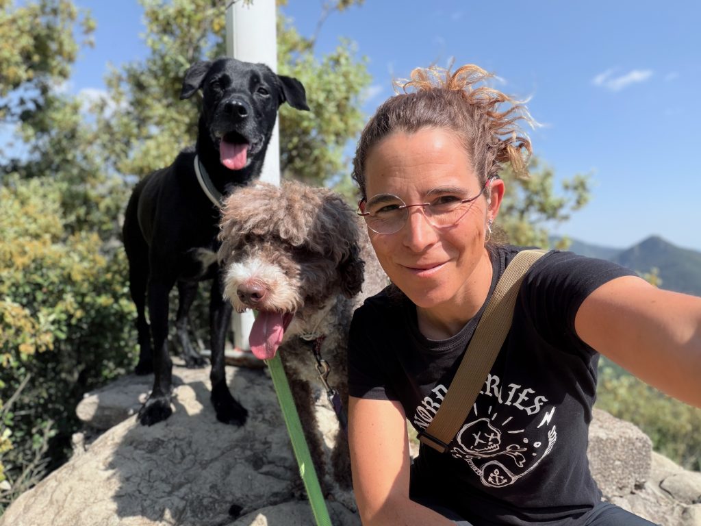 Ariadna junto a sus dos perros en un entorno de montaña.